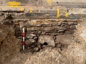 The original medieval wall and 
foundation of the Great South Aisle. 
The large circular block of stone in 
the centre appears to be part of a 
recycled quern stone. Image: ULAS