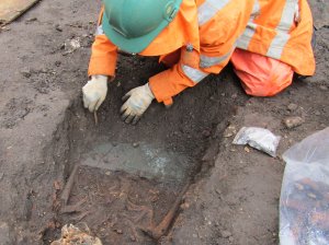 An archaeologist carefully 
excavates a name plate on a 
coffined burial at Leicester 
Cathedral. Image: ULAS