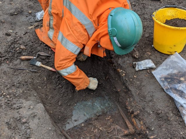 A University of Leicester archaeologist carefully excavates the brass name plate on John Ottey's 
coffin. The inscription read 'John Wilson Ottey, died 31st May 1851, aged 40'. Image: ULAS