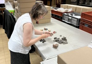 Image 1. Elizabeth Johnson examines Roman pottery from Leicester Cathedral. Image: ULAS